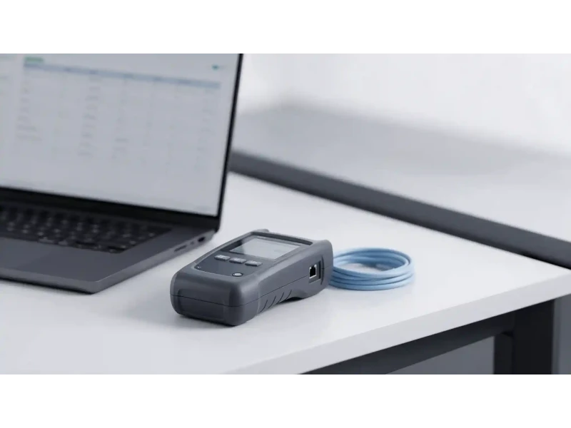 Cable test report — certification results reviewed on screen beside a field tester